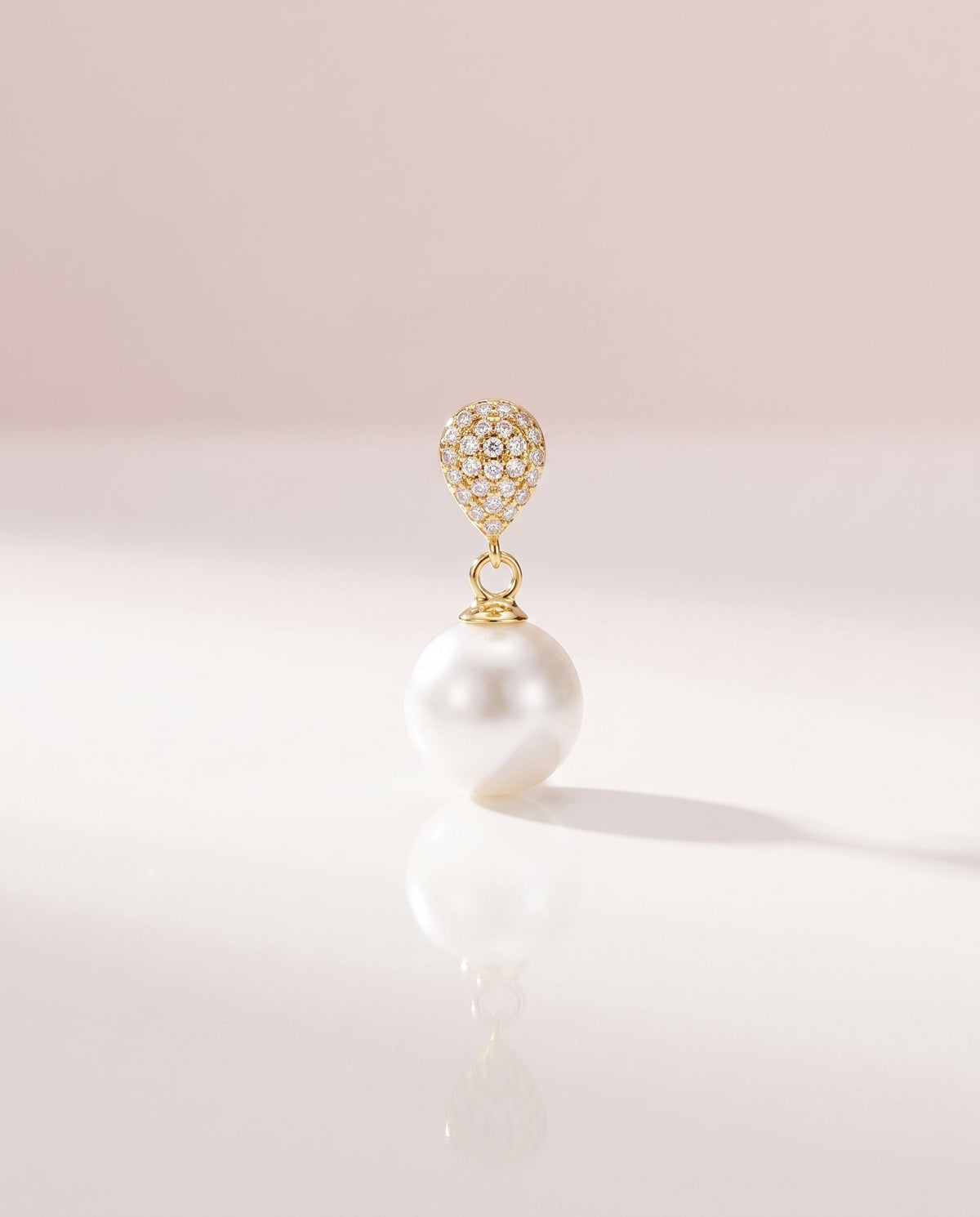 Gold pave pearl drop earring, freshwater pearl, on a glossy pedestal
