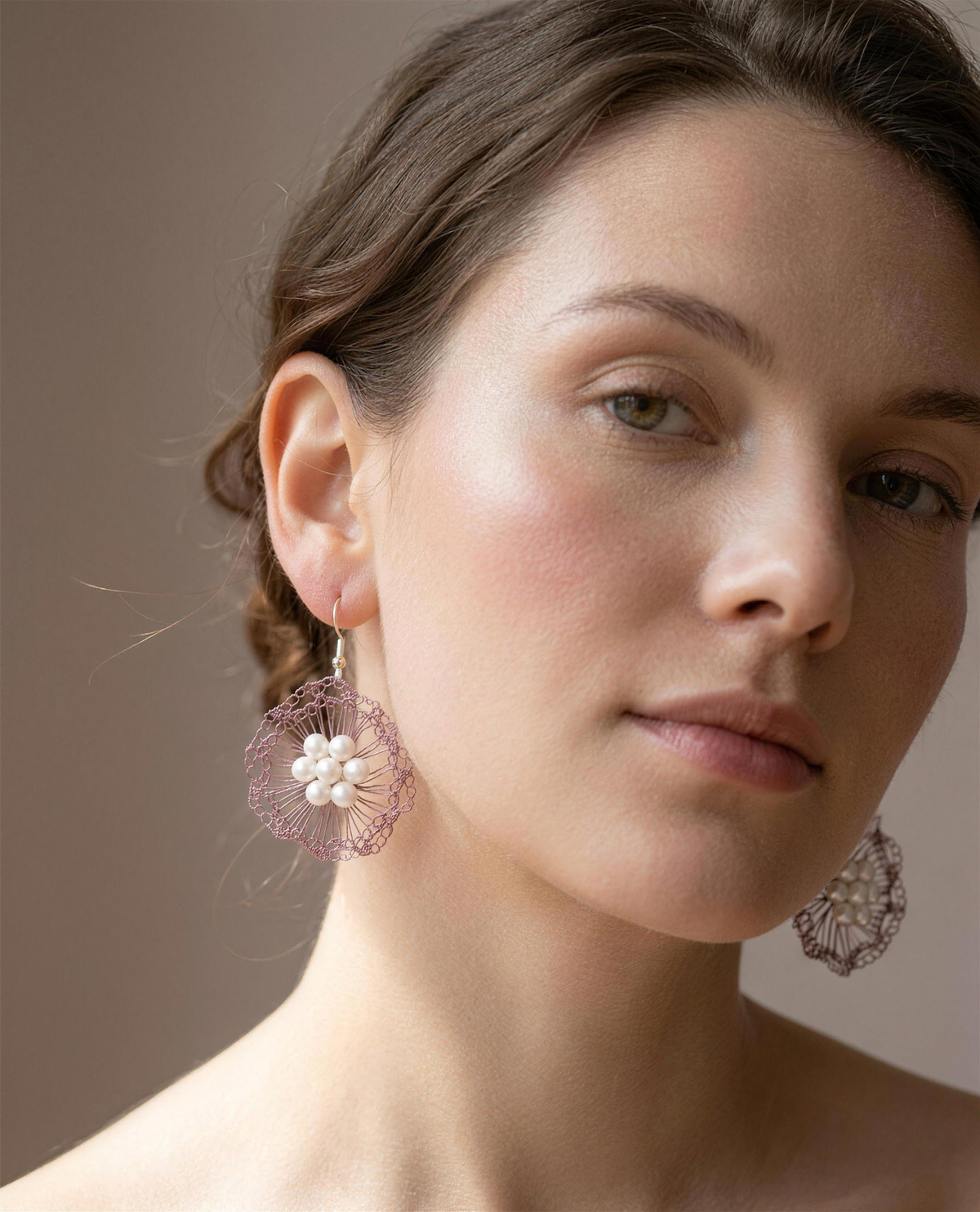 Freshwater pearl rose bloom drop earrings worn on the ear, head tilted.