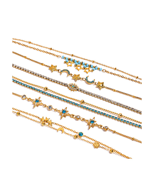 Six gold star and moon bracelets laid flat on pure white