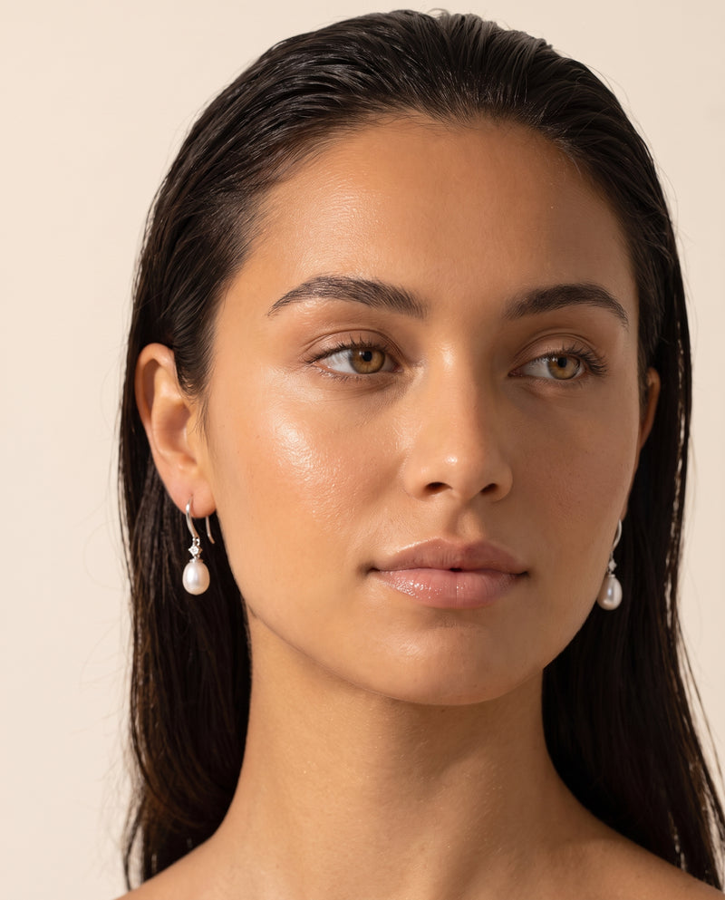 Pair of freshwater pearl drop earrings worn, front view