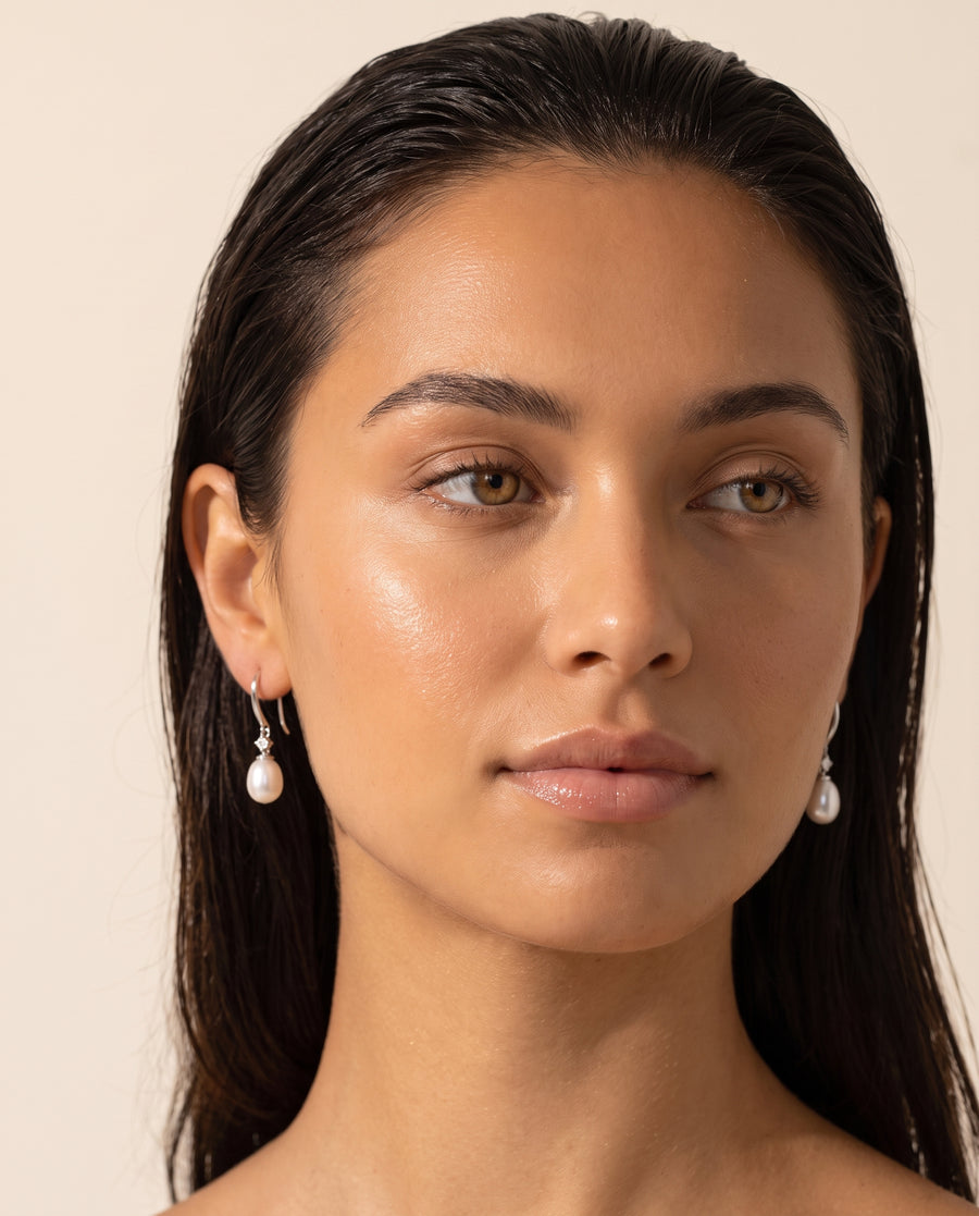 Pair of freshwater pearl drop earrings worn, front view