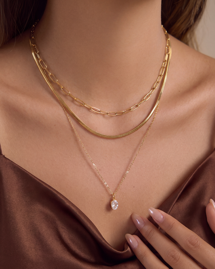 Layered gold necklace set worn with a chocolate satin camisole
