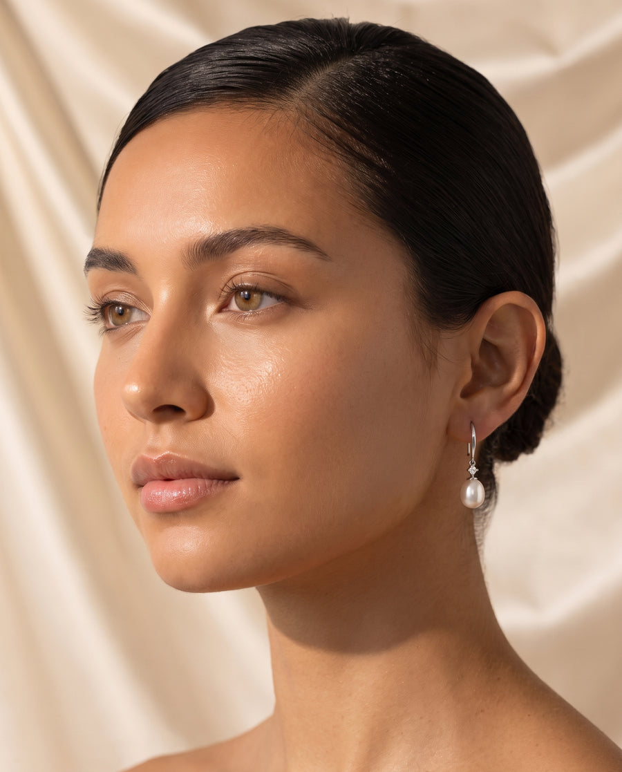 Freshwater pearl drop earring editorial portrait on champagne silk backdrop