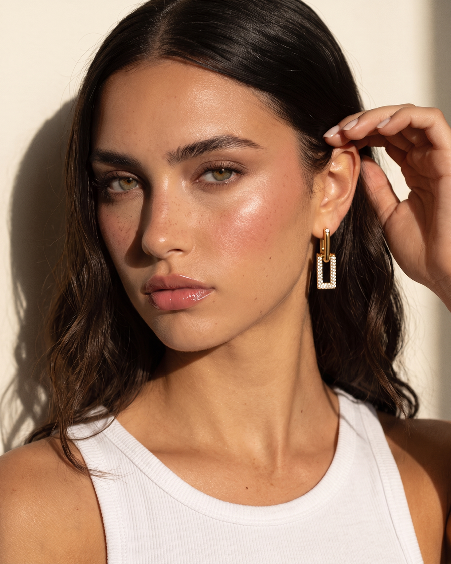 Model tucking her hair behind her ear to show the pavé link drop earring
