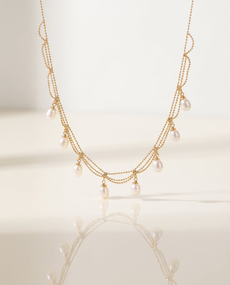 Gold Pearl Fringe Necklace on pedestal