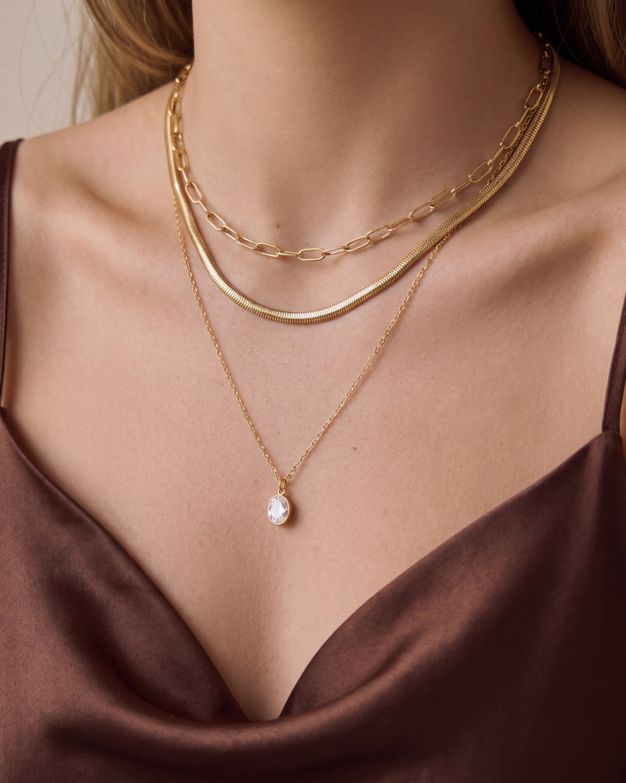 Close view of the three layered gold chains on the collarbone