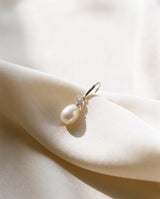 Freshwater pearl drop earring draped on champagne ivory silk