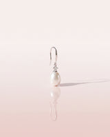 Freshwater pearl drop earring on a glossy pedestal with soft reflection