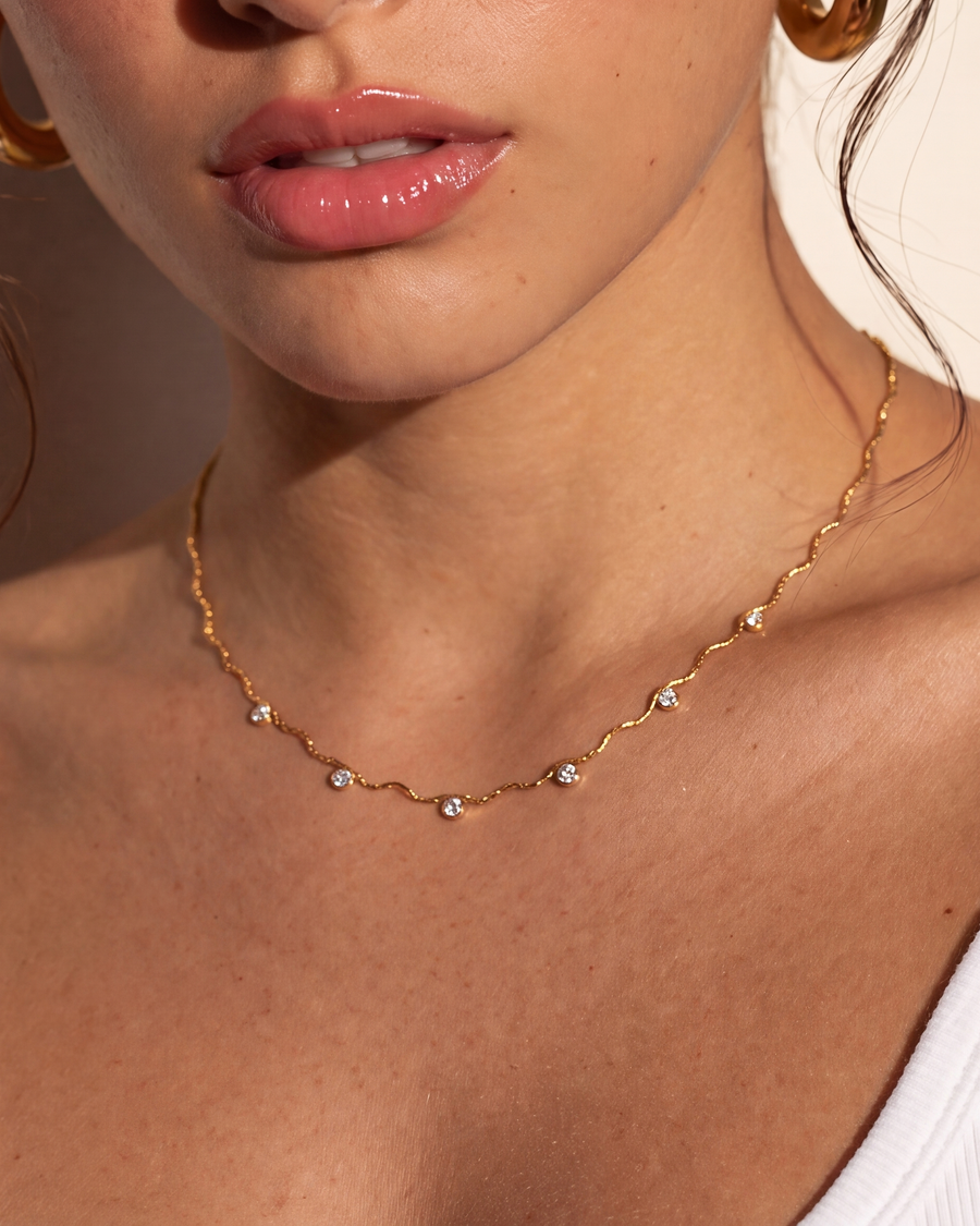 Close view of the necklace on the neck, all five clear stones visible