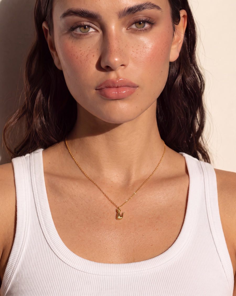 Close view at the throat showing the cat pendant on its fine chain