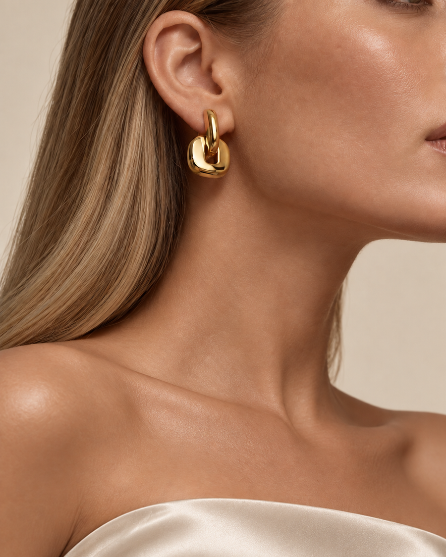 Tandem link huggie earrings in 18k gold plated stainless steel, worn on model ear