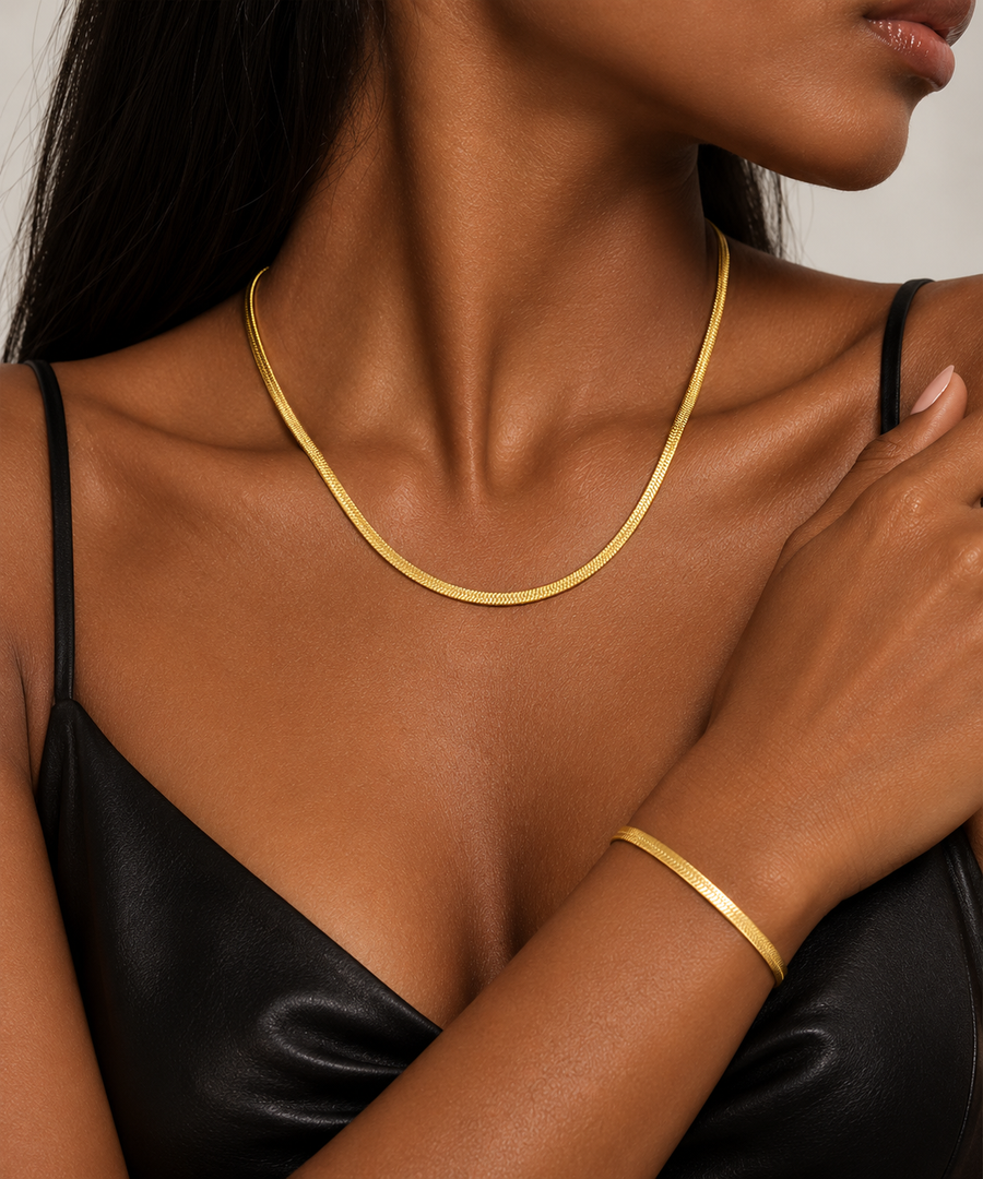 Herringbone chain worn as a necklace and as a bracelet together with a black slip dress