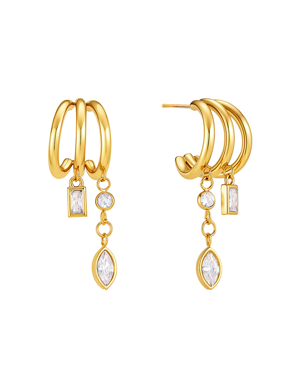 Tassel hoop earrings on white — three fine gold half-hoops with two chains carrying a baguette, a round and a marquise crystal