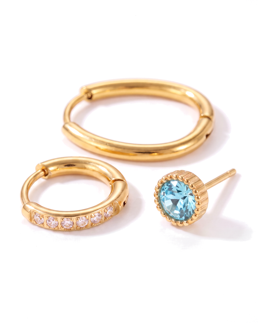Close view of the pave hoop and the aqua stud, showing the single row of clear crystals and the fluted gold bezel