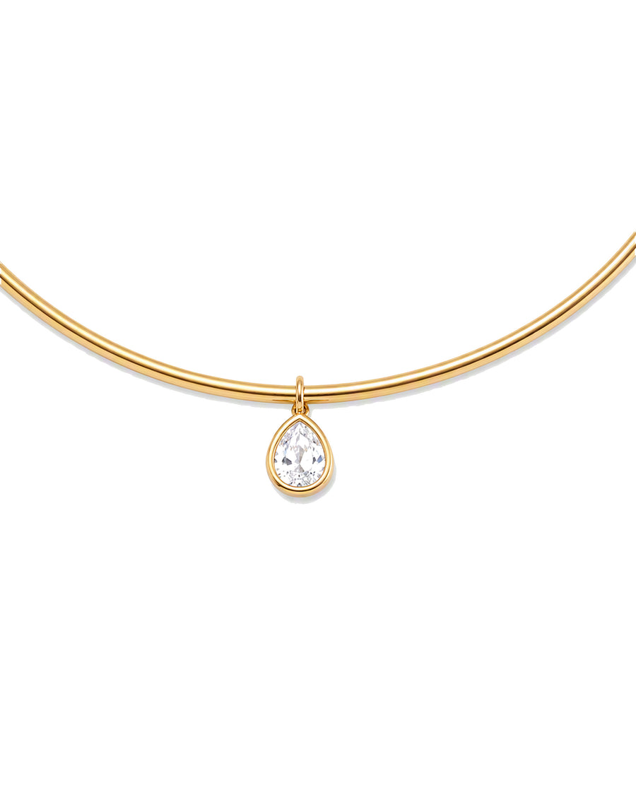 Close detail of the bezel-set clear pear-cut stone hanging from the gold collar bar