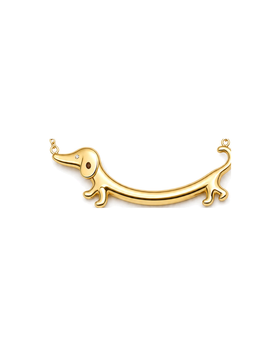 Close detail of the gold dachshund bar pendant, 5.0 cm long, on white