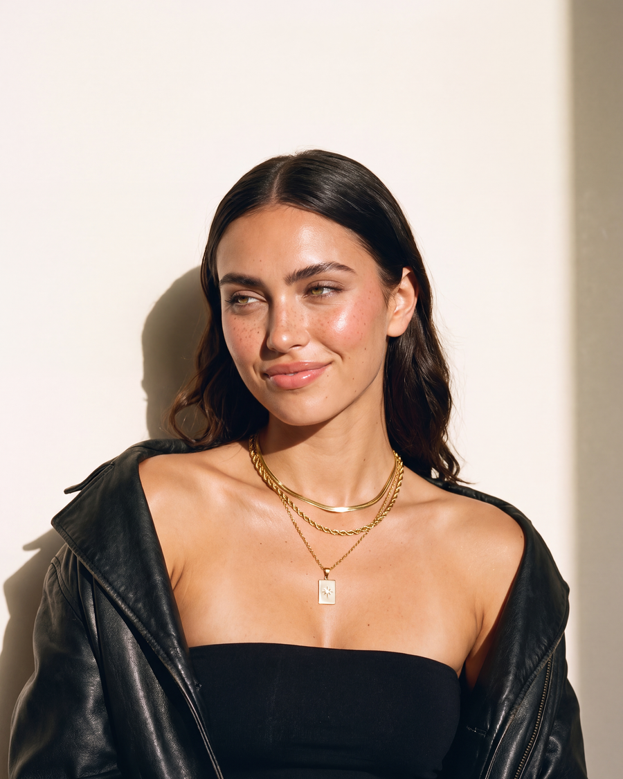 Model smiling, wearing the layered necklace
