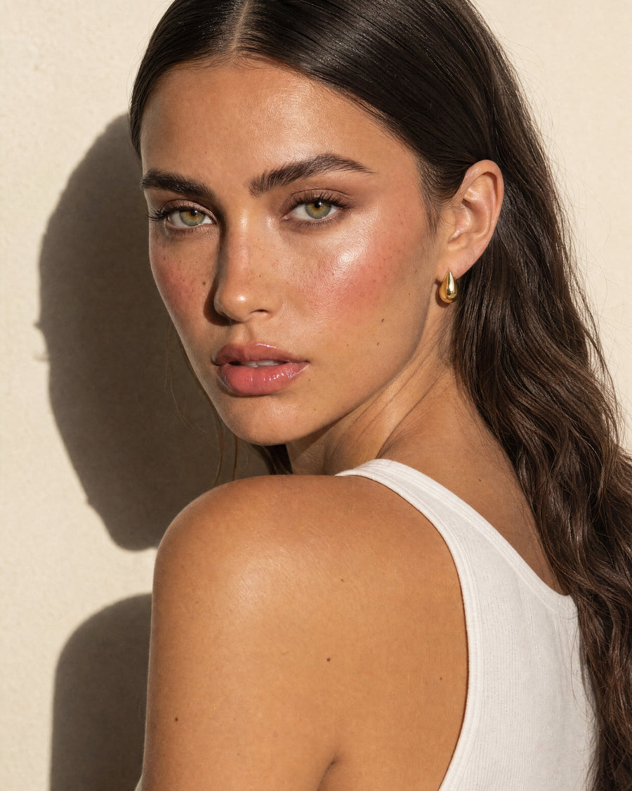Teardrop Huggie earring seen from behind the shoulder