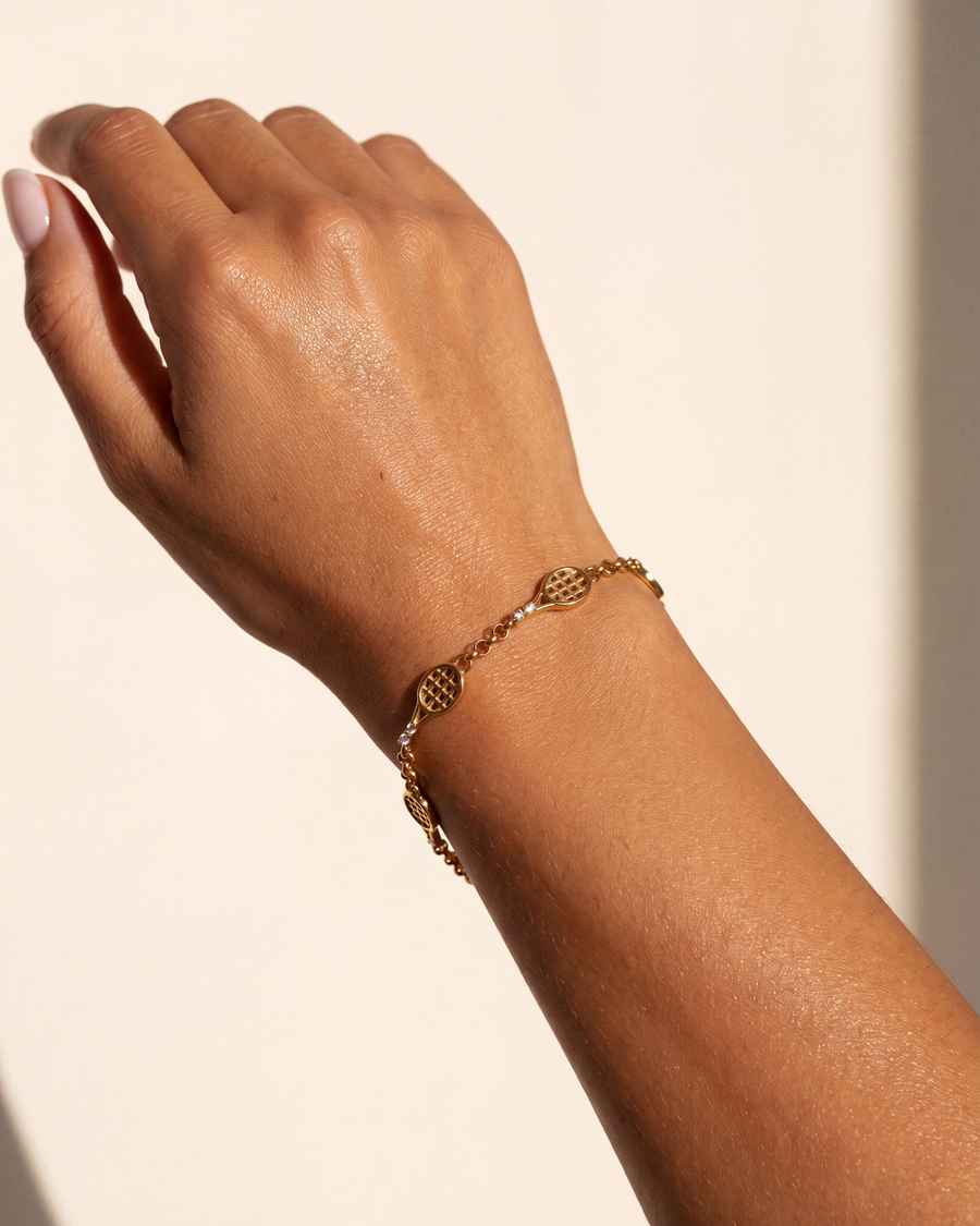 The five-racquet bracelet worn on one wrist, racquets lying flat in line