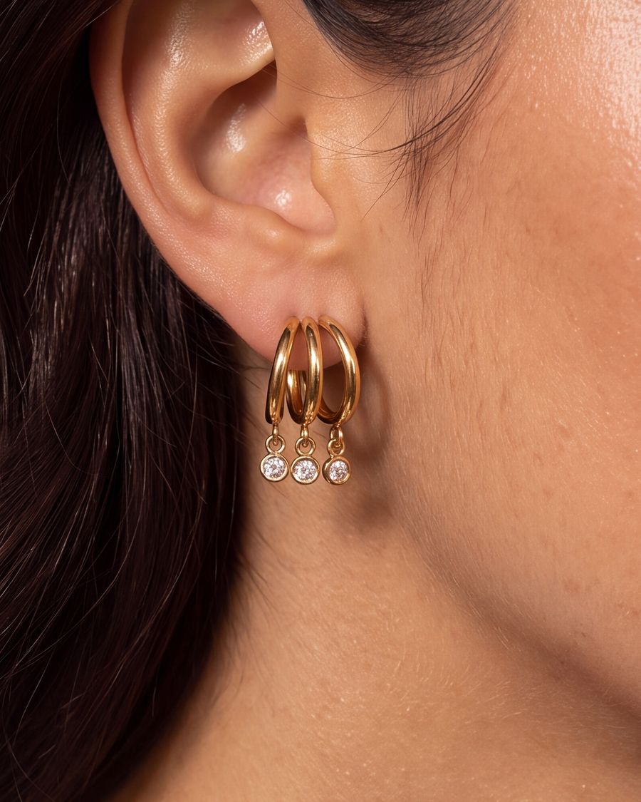 Close detail of the triple hoop earring on the ear, three crystals hanging in a row