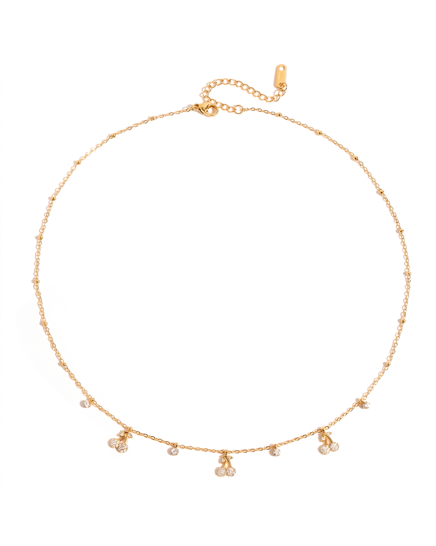 Cherry charm necklace laid flat on white with clasp and extender