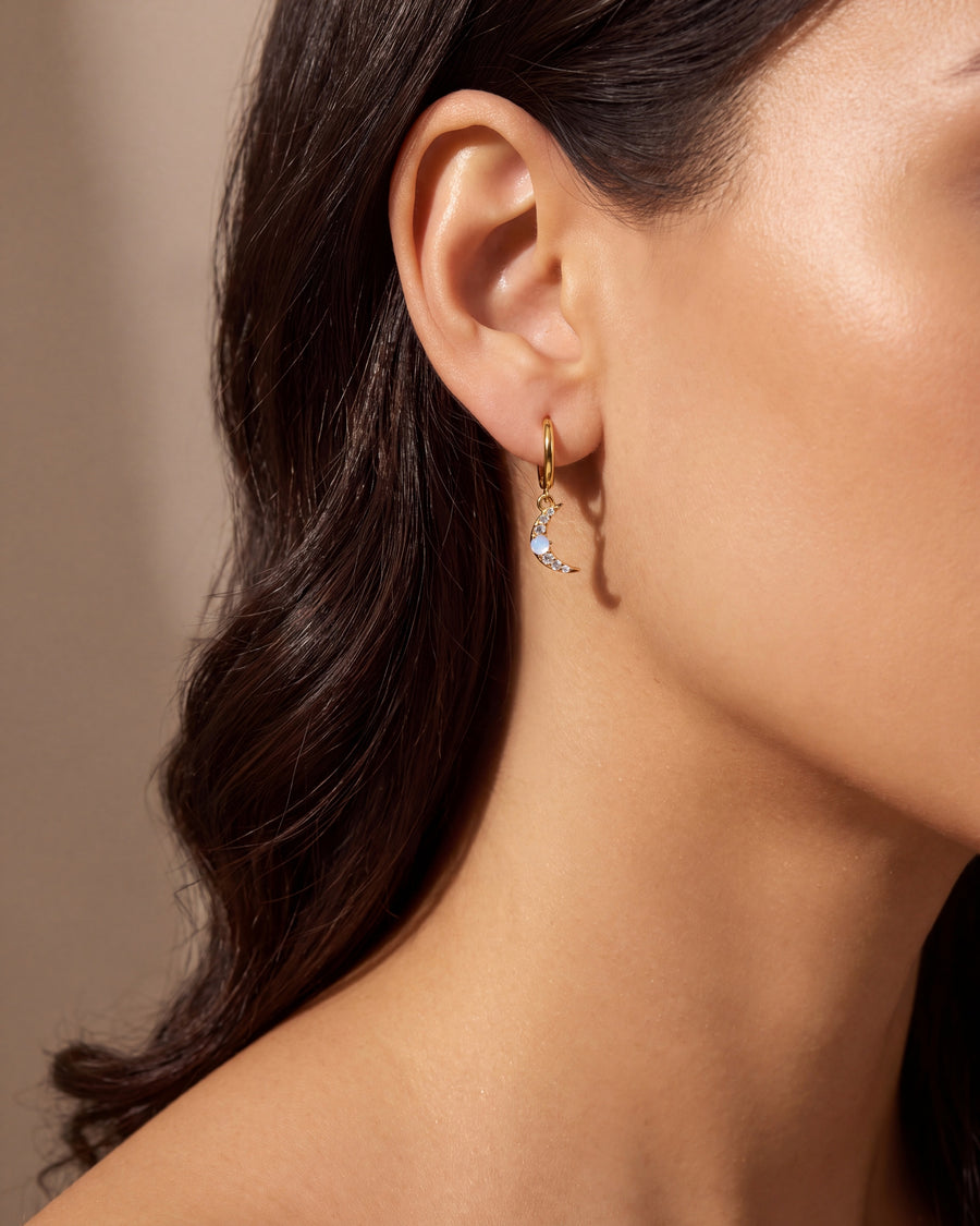 Crescent moon huggie earring worn on the earlobe