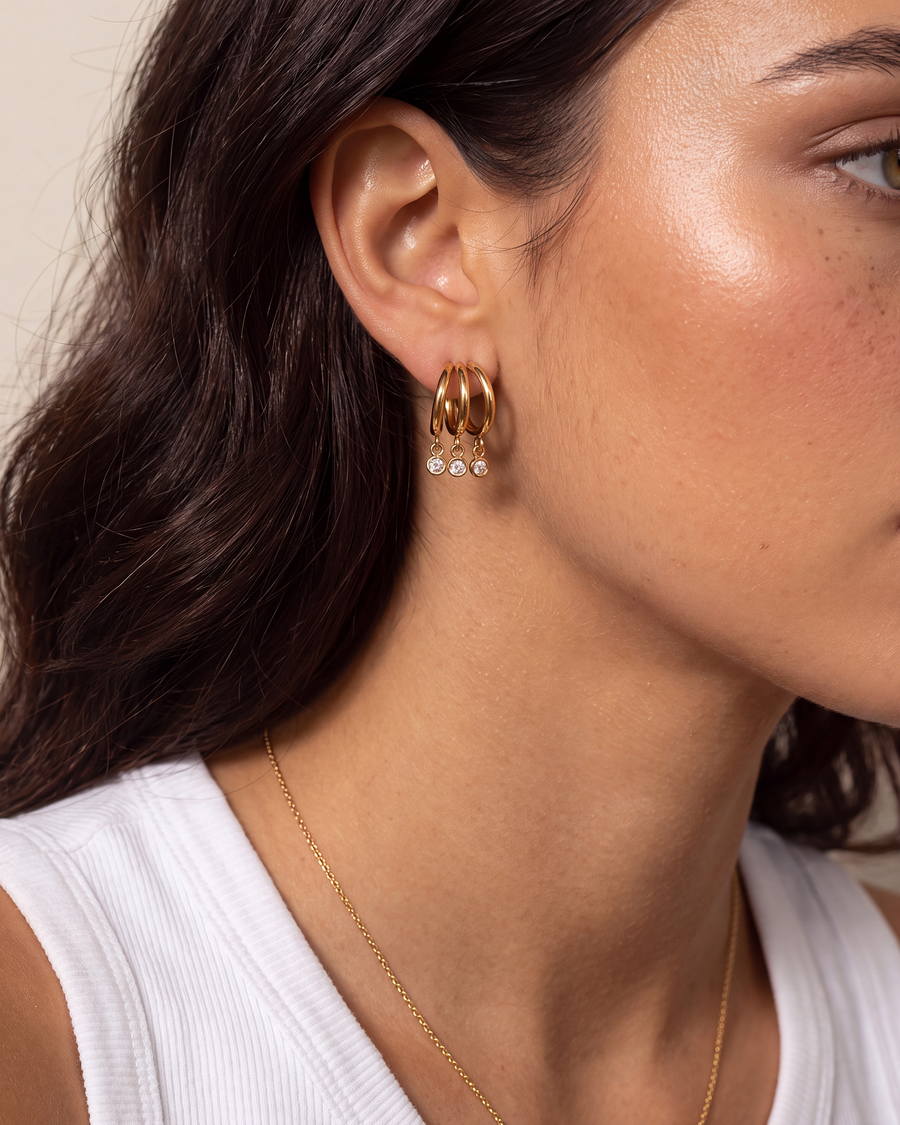 Model wearing the triple hoop crystal drop earring, shown at its true small scale on the earlobe