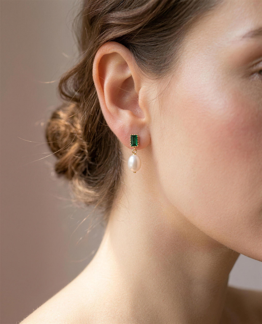 Green stone freshwater pearl drop earrings worn on the ear, side view.