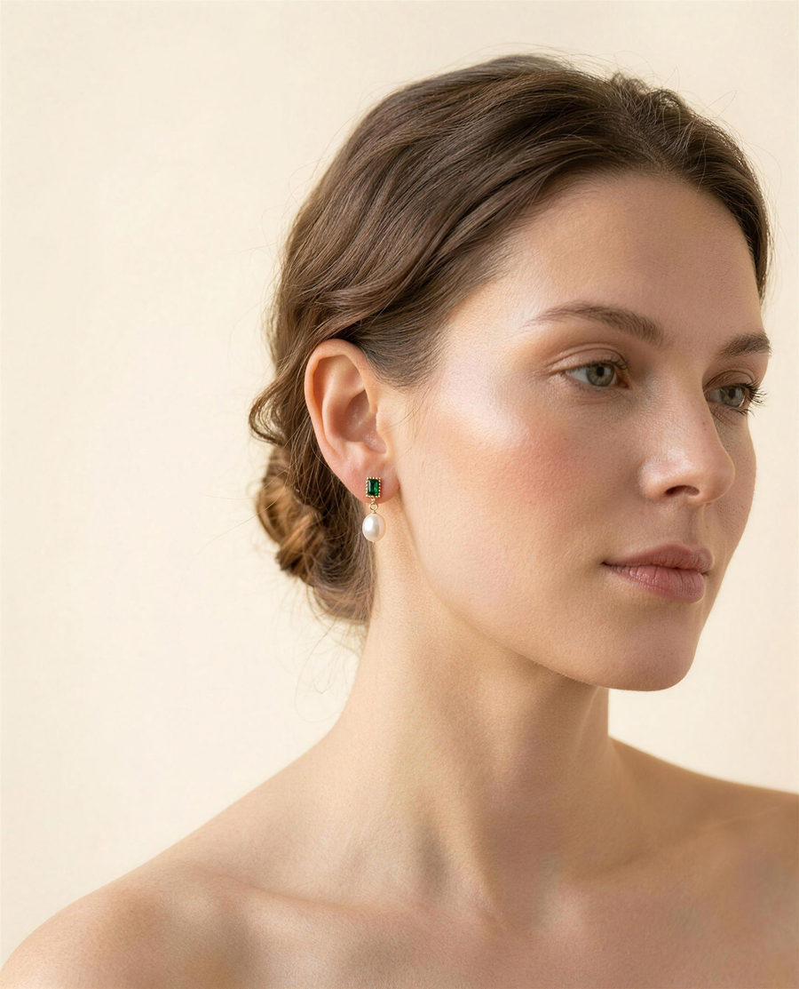 Green stone freshwater pearl drop earrings worn on the ear, side profile.