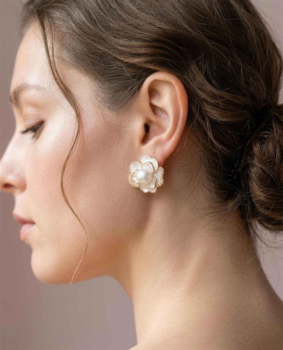 Camellia freshwater pearl stud earrings worn on the ear, close portrait.
