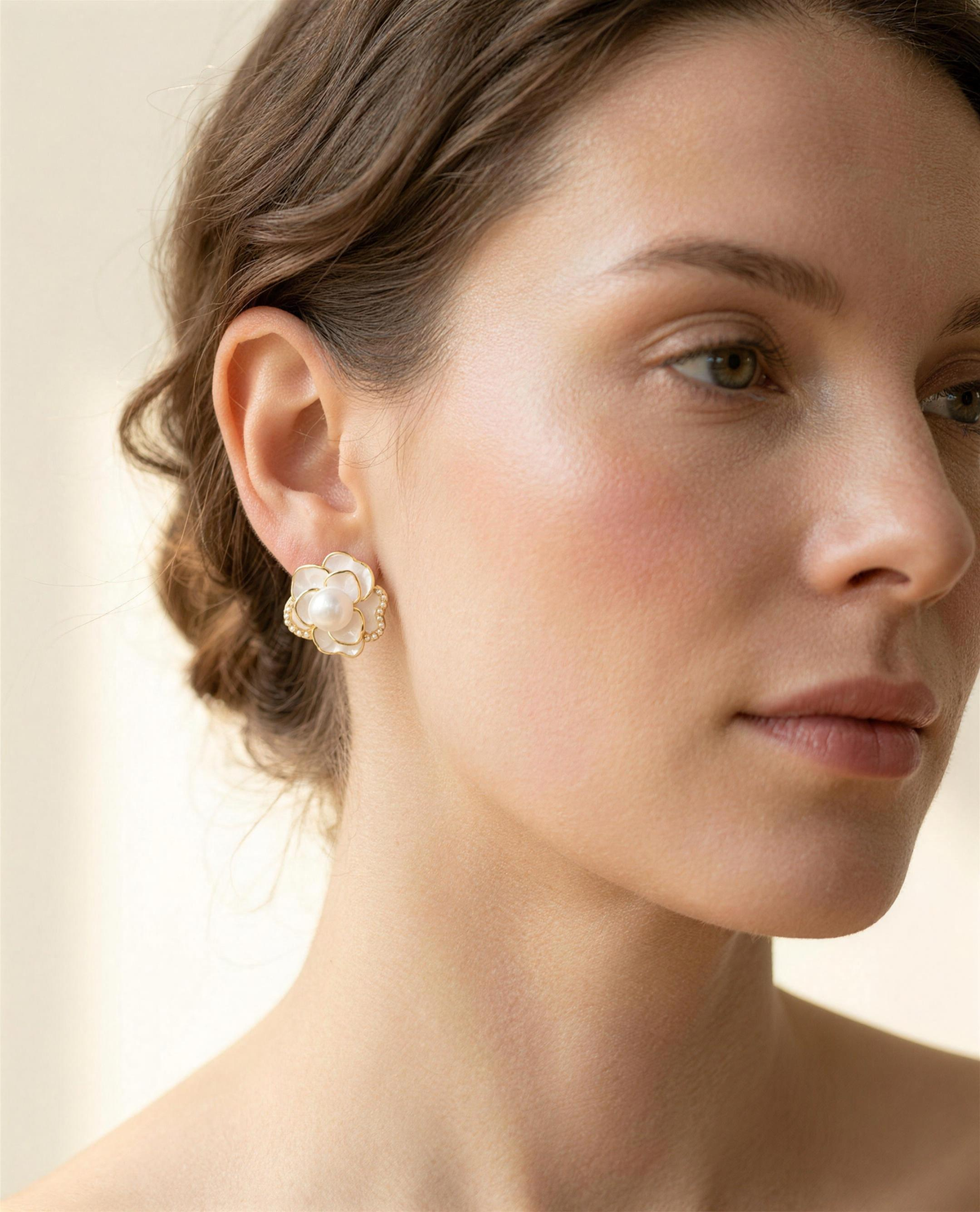 Camellia freshwater pearl stud earrings worn on the ear, side profile.