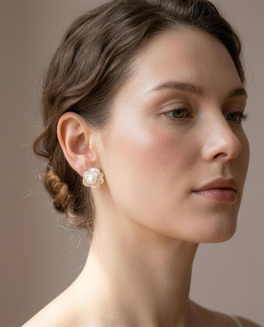 Camellia freshwater pearl stud earrings worn on the ear, head tilted.