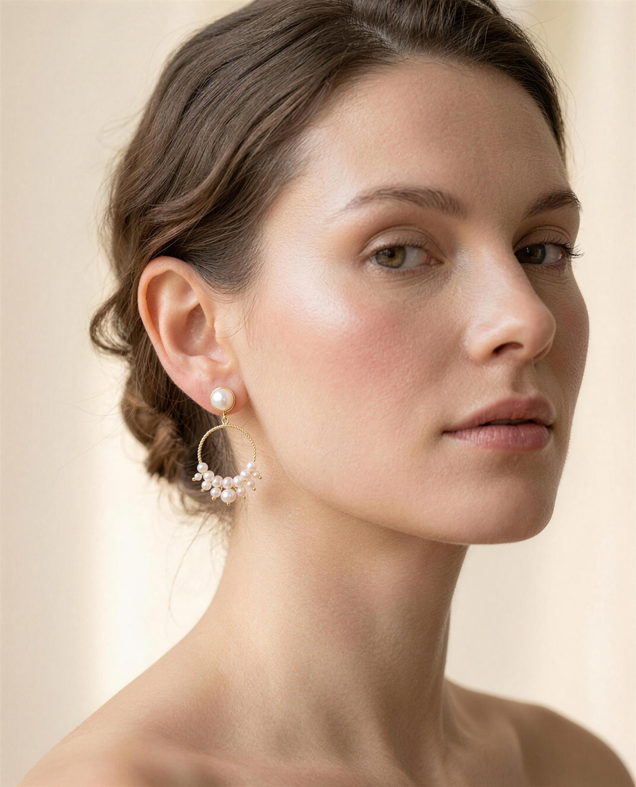 Freshwater pearl cluster hoop earrings worn on the ear, three-quarter view.