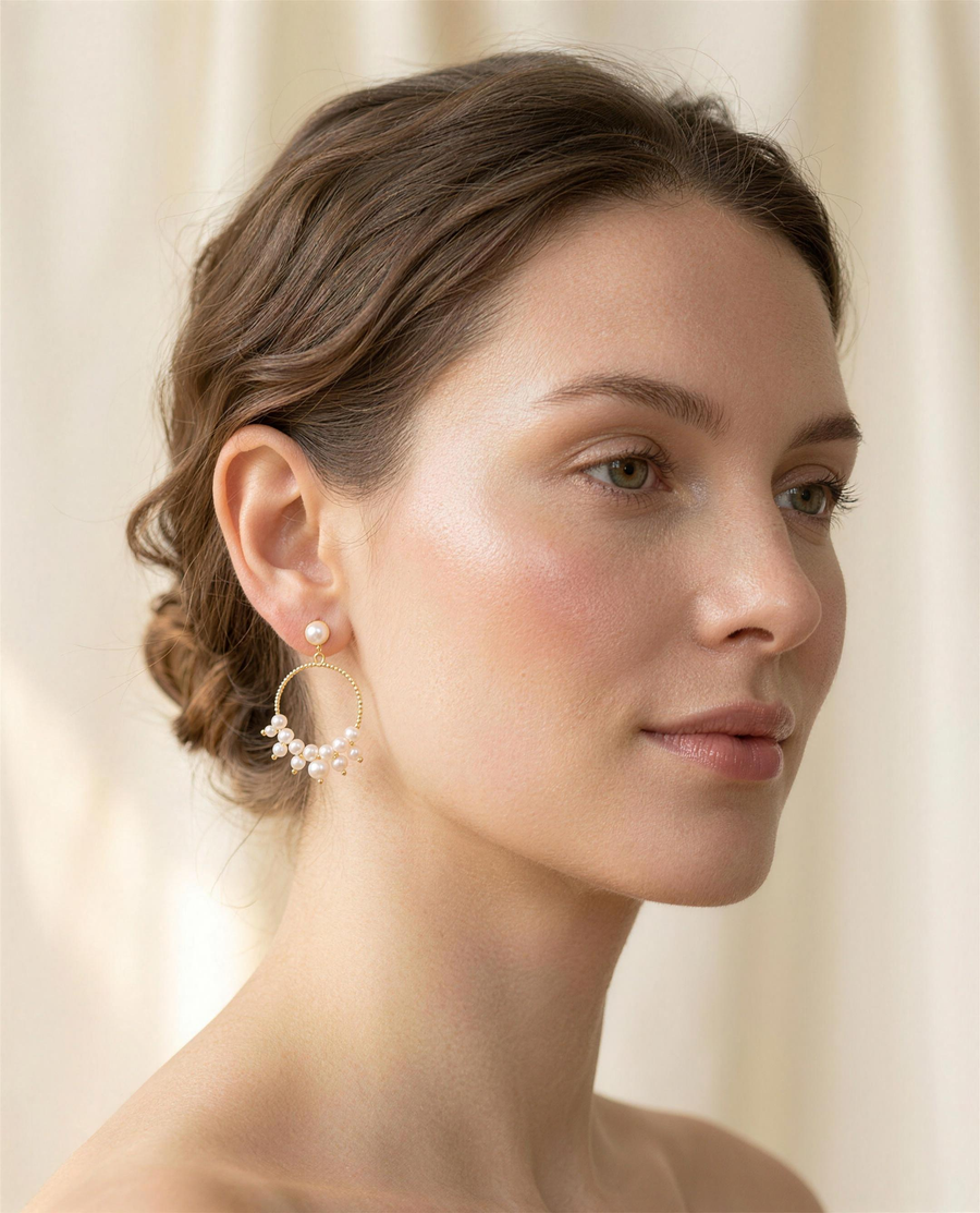 Freshwater pearl cluster hoop earrings worn on the ear, side profile.