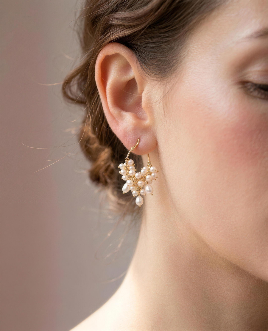 Freshwater pearl cascade hoop earrings shown close on the ear.