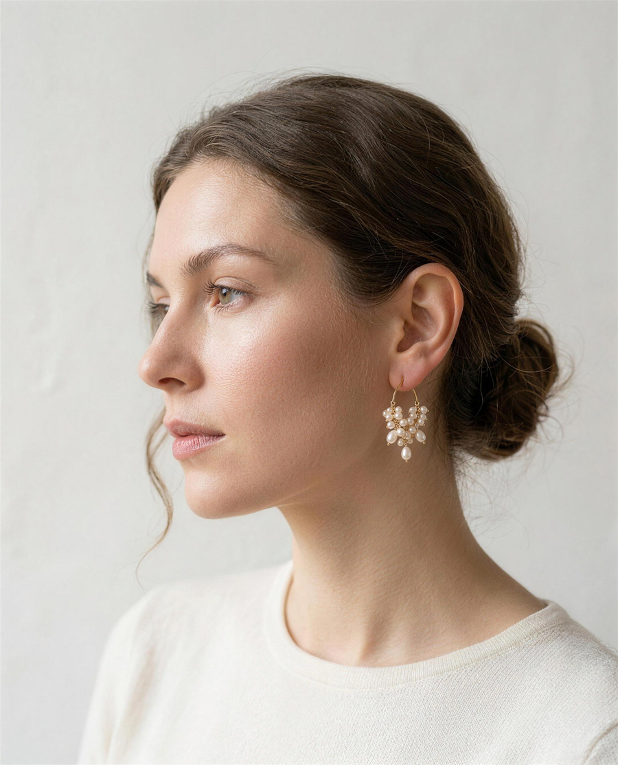 Freshwater pearl cascade hoop earrings worn on the ear, side profile.