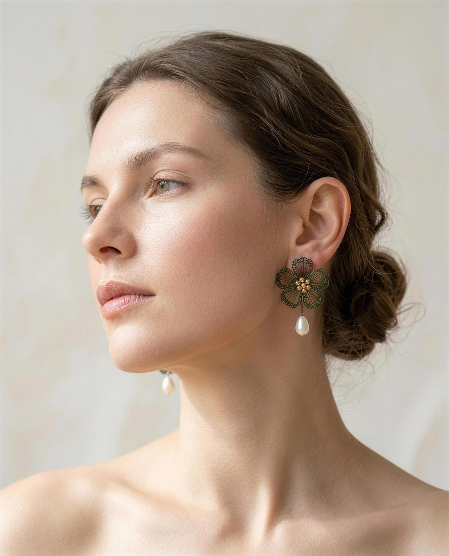 Freshwater pearl wildflower drop earrings worn on the ear, side profile.