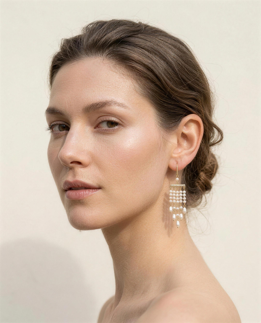 Freshwater pearl tassel drop earrings worn on the ear, three-quarter view.
