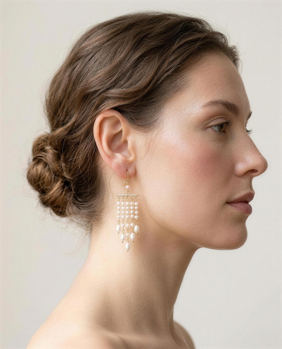 Freshwater pearl tassel drop earrings worn on the ear, side profile.