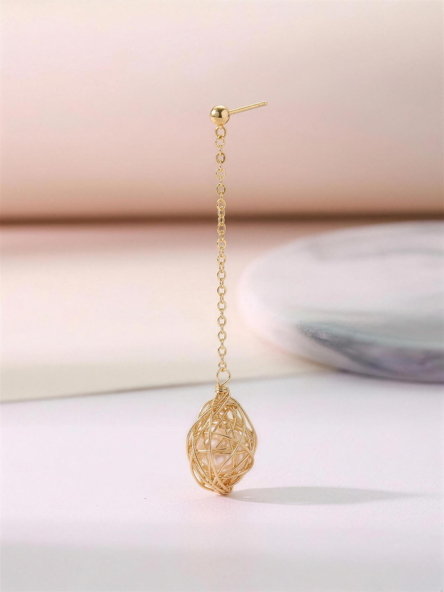 Gold caged freshwater pearl drop earrings in our Ontario atelier.
