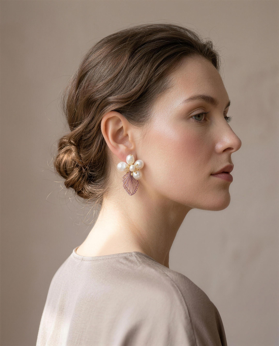 Baroque pearl blossom stud earrings worn on the ear, side view.
