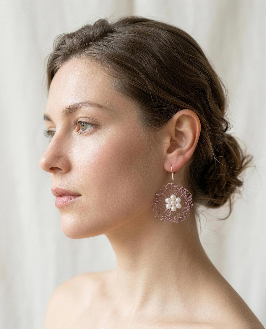 Freshwater pearl rose bloom drop earrings worn on the ear, side profile.