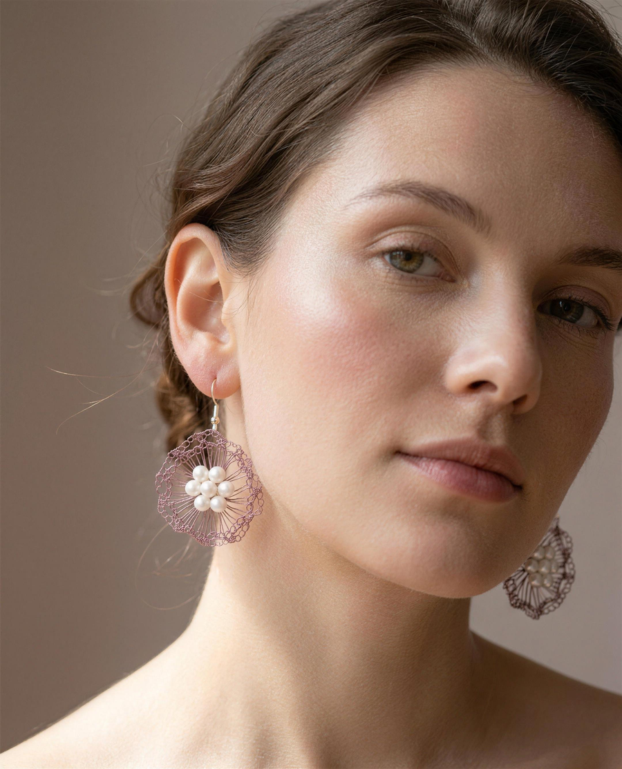 Freshwater pearl rose bloom drop earrings worn on the ear, head tilted.
