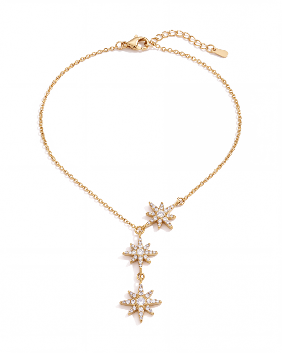 Gold necklace with three pave north stars linked point to point, white background