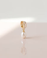 Shell Inlay Pearl Huggie Drops freshwater pearl earring on a glossy pedestal with soft reflection