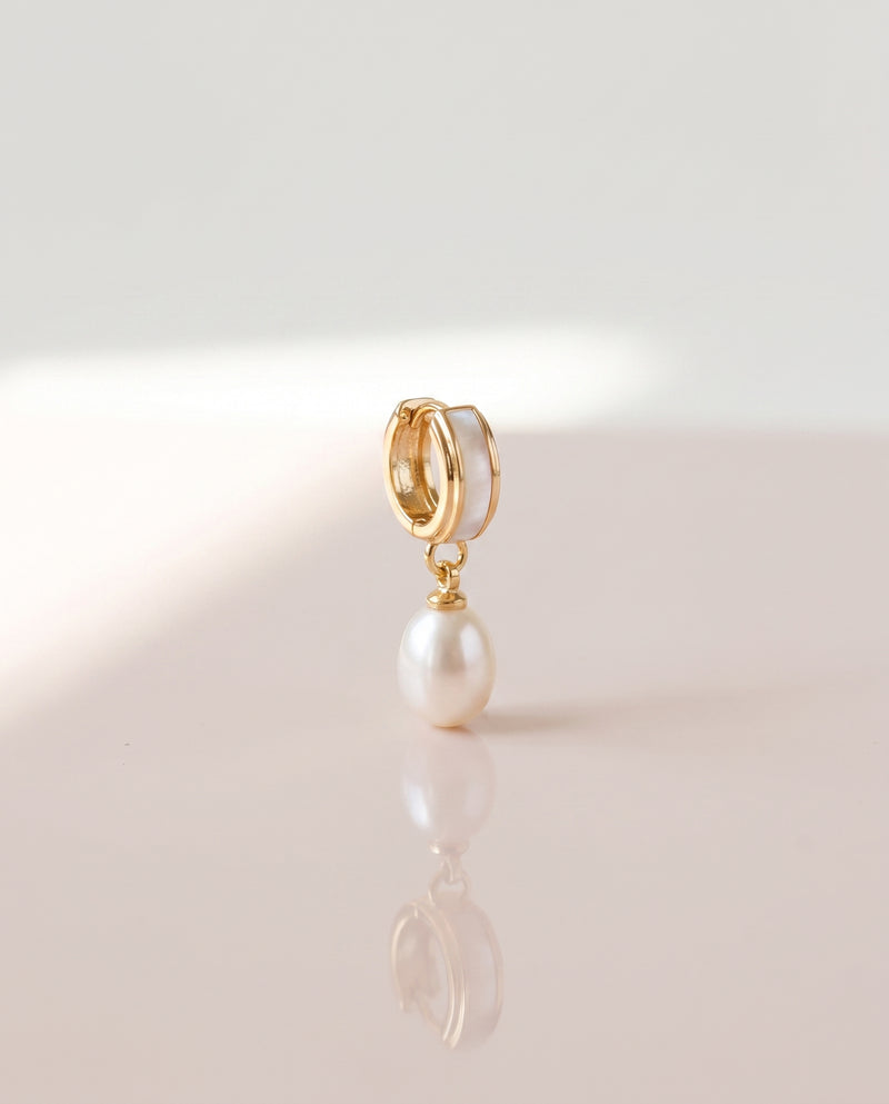Shell Inlay Pearl Huggie Drops freshwater pearl earring on a glossy pedestal with soft reflection