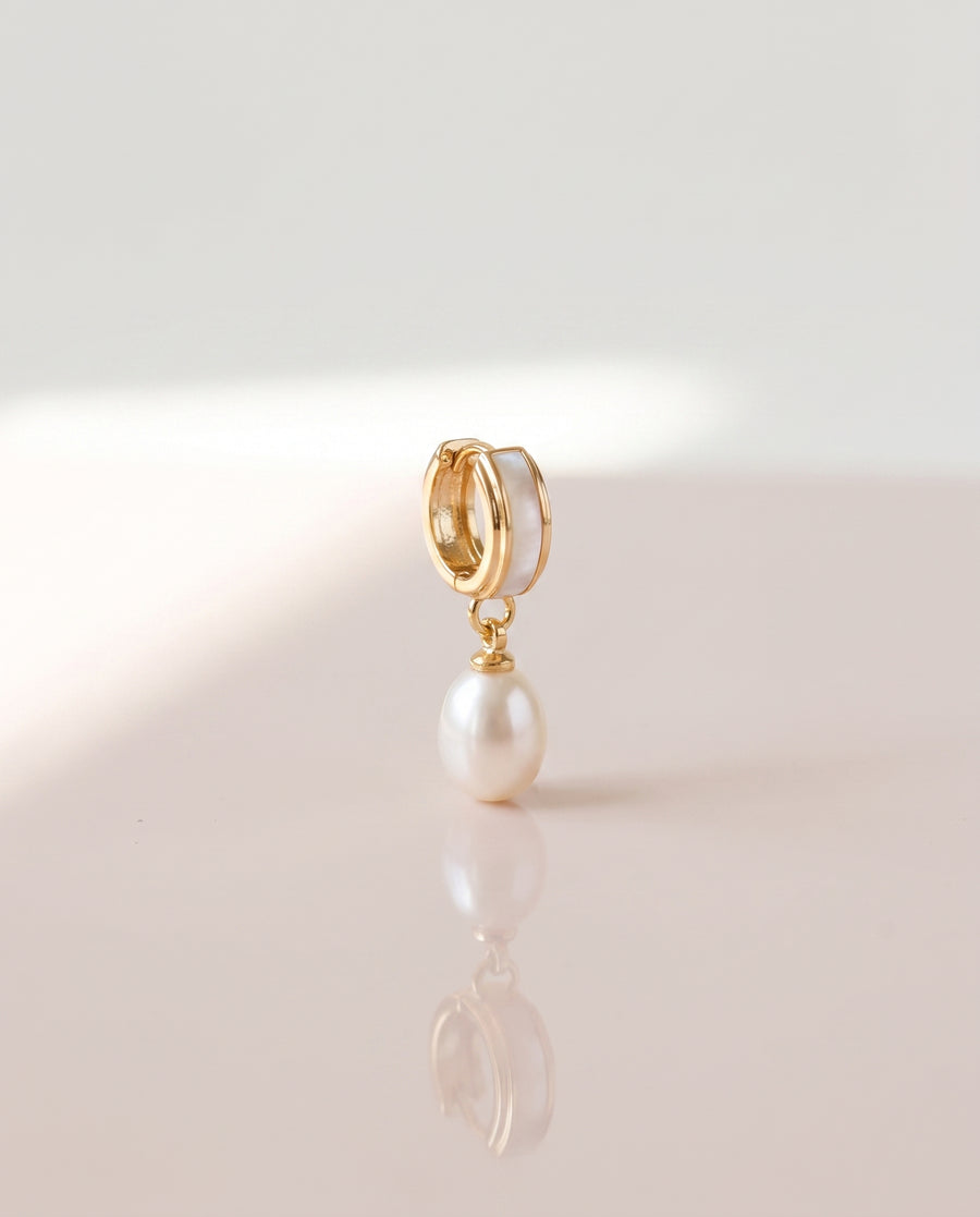 Shell Inlay Pearl Huggie Drops freshwater pearl earring on a glossy pedestal with soft reflection