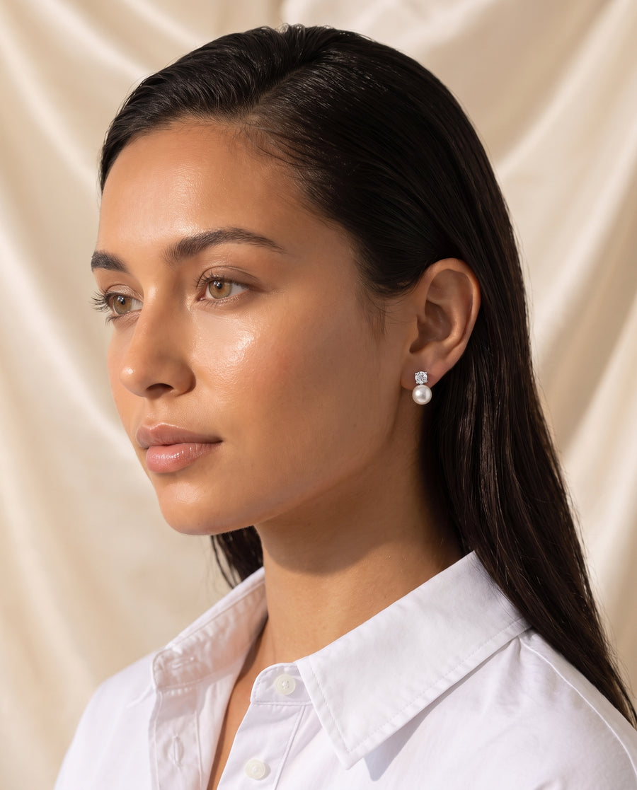 Solitaire and Pearl Studs freshwater pearl earring editorial portrait on champagne silk