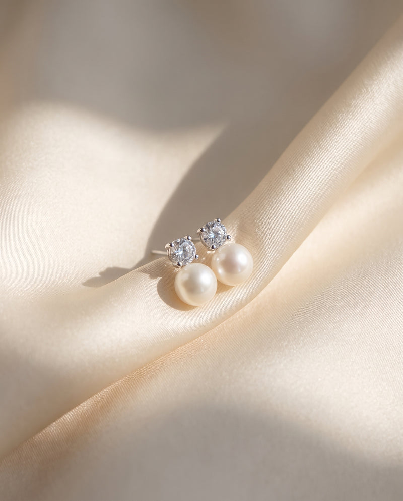 Solitaire and Pearl Studs freshwater pearl earring draped on champagne ivory silk