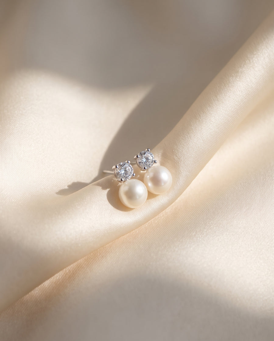 Solitaire and Pearl Studs freshwater pearl earring draped on champagne ivory silk